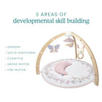 Ma Fleur Activity Gym with wooden arch and soft floral play mat featuring hanging butterfly, bird, and bunny toys designed to support sensory, socio-emotional, cognitive, gross motor, and fine motor skill development.