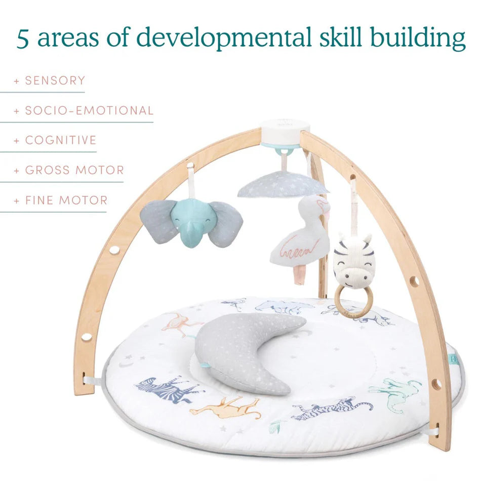 Rising Star Play + Discovery Activity Gym with wooden arches, plush elephant, swan, and zebra toys hanging above a soft animal-print mat, promoting sensory, motor, and cognitive development.
